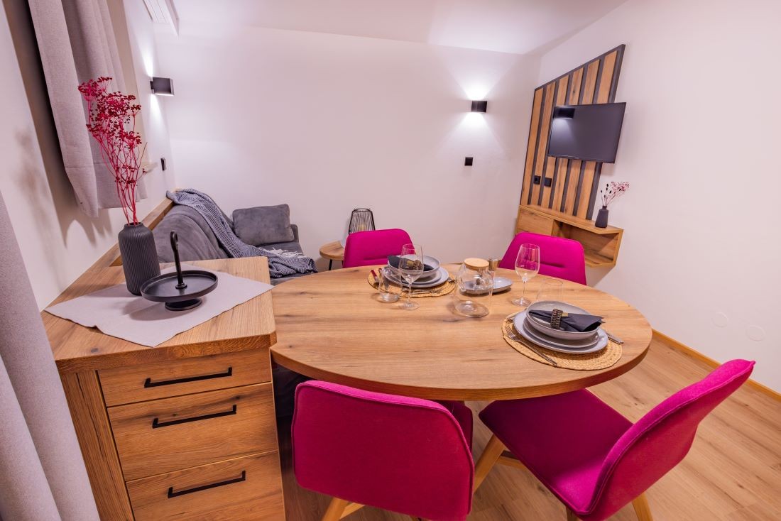 Wohnzimmer mit Flat-TV und Esstisch